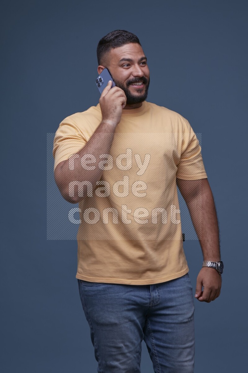 A man Calling on Blue Background wearing Orange T-shirt