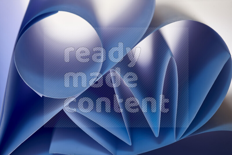 عرض فني لطيات الورق تخلق مزيج من الأشكال الهندسية، مضاءة بإضاءة ناعمة بدرجات اللون الأزرق