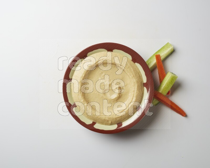 Plain hummus in a traditional plate on a white background