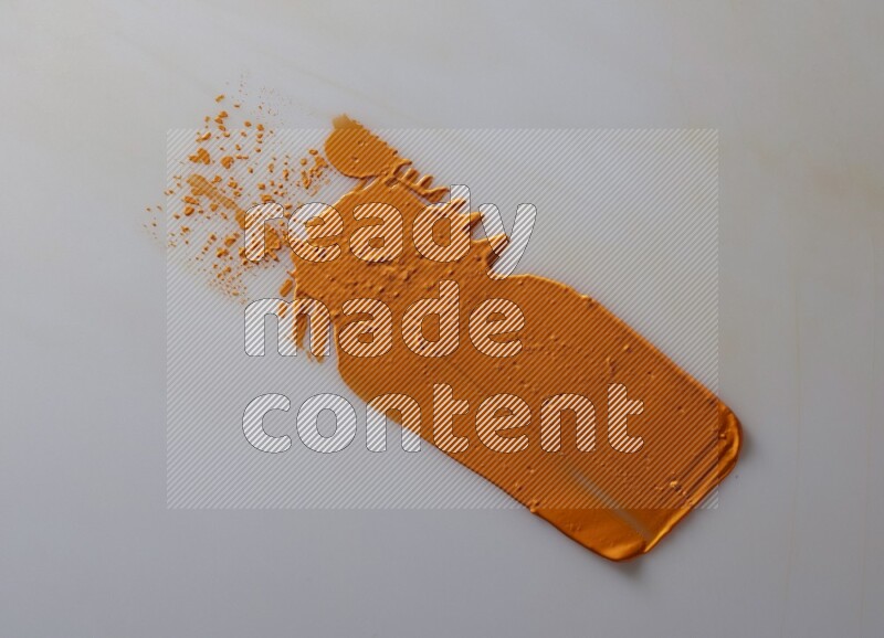 An orange straight painting knife stroke on white background