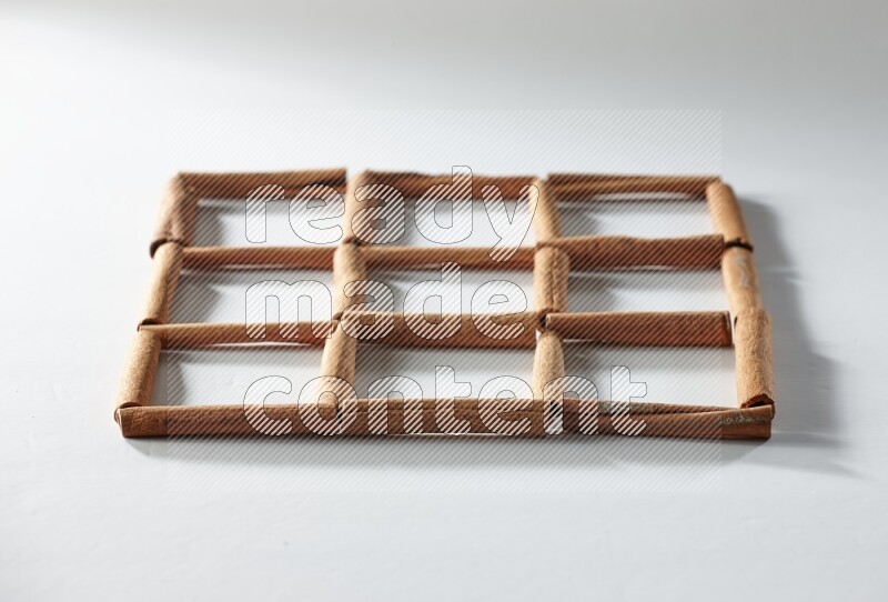 9 empty squares of cinnamon sticks on white flooring