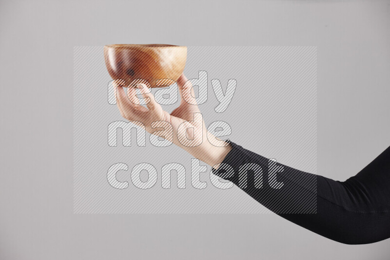 امرأة ترتدي عباءة سوداء تحمل أدوات خشبية مختلفة في أوضاع متعددة