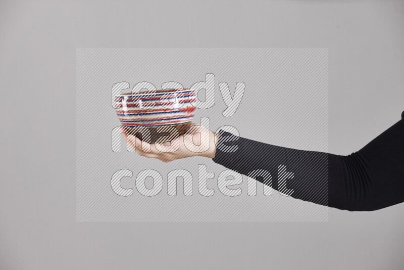 امرأة ترتدي عباءة سوداء تحمل أدوات فخارية مختلفة في أوضاع متعددة