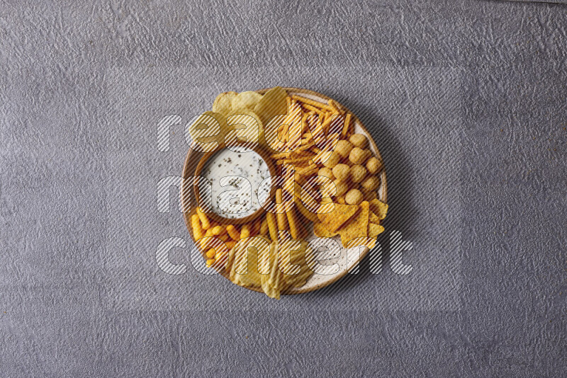 Assorted snacks in pottery bowls on grey background
