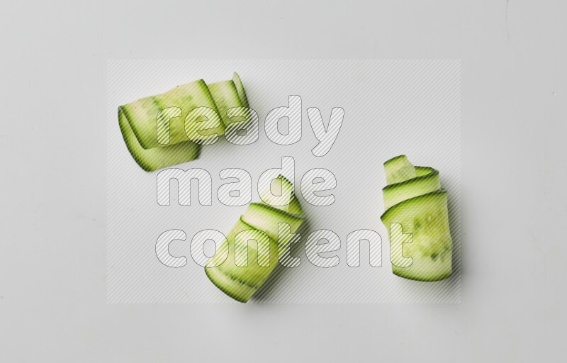 Three cucumber ribbons on a white background