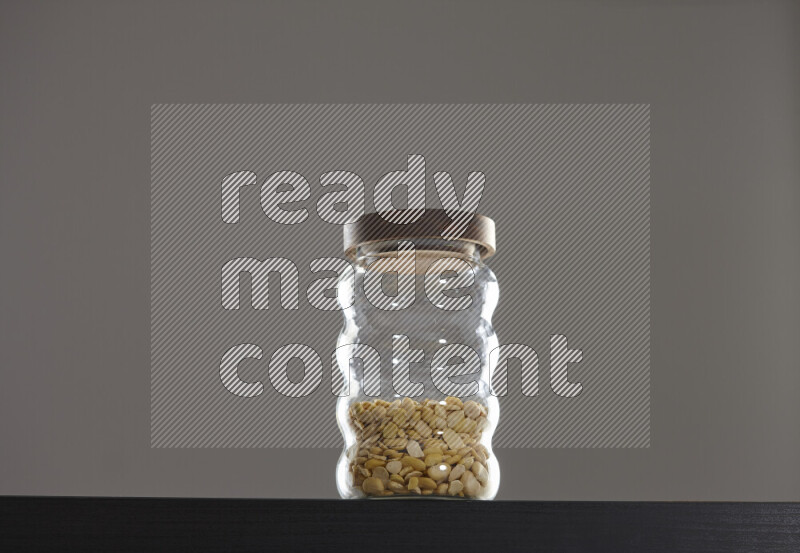 Crushed beans in a glass jar on black background