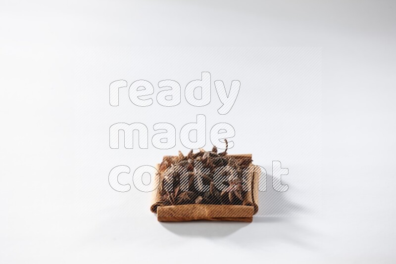 A single square of cinnamon sticks full of star anise on white flooring