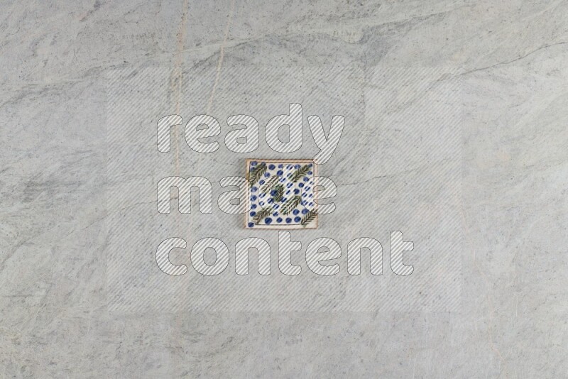 A decorative pottery coaster on grey marble background