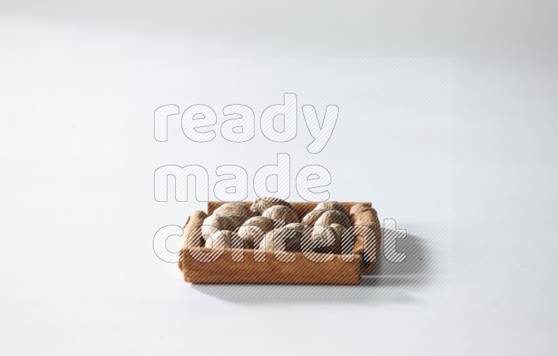 A single square of cinnamon sticks full of nutmeg on white flooring