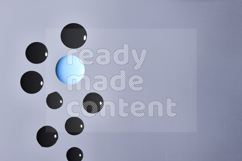 Close-ups of abstract blue and black paint droplets on the surface