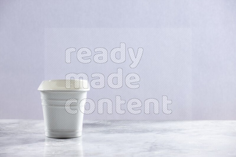An empty white plant pot on grey marble background