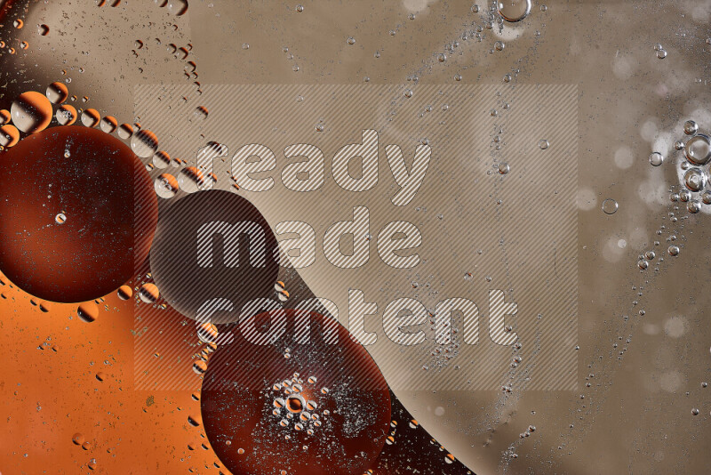 Close-ups of abstract oil bubbles on water surface in shades of orange and brown