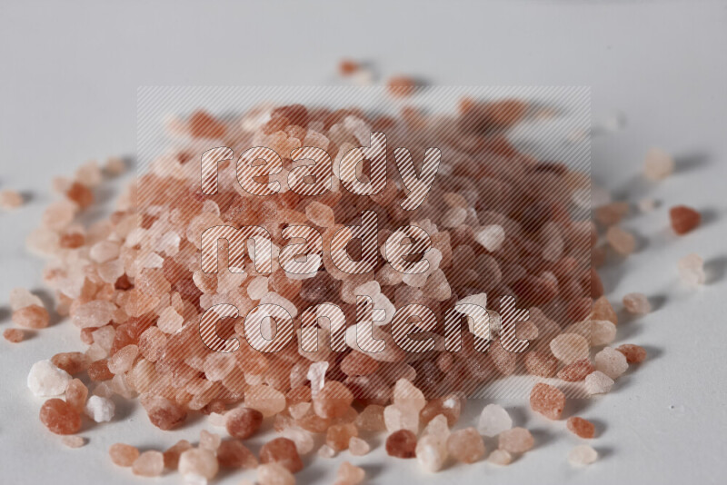 A bunch of coarse himalayan salt crystals on white background