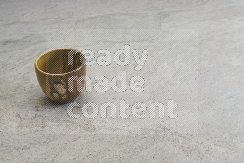 A multicolored pottery bowl on grey marble background