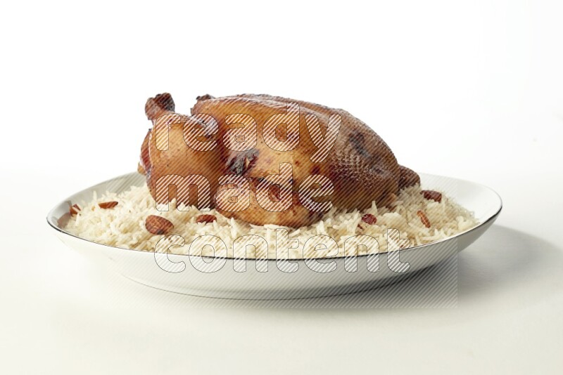 white  basmati Rice with  whole roasted chicken  on a white plate with a silver rim direct  on white background