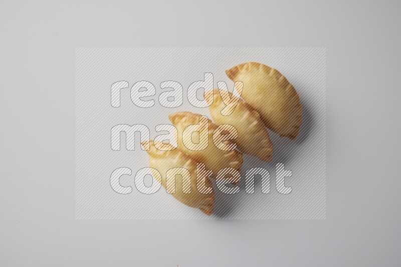 Four fried sambosa from a top angle on a white background