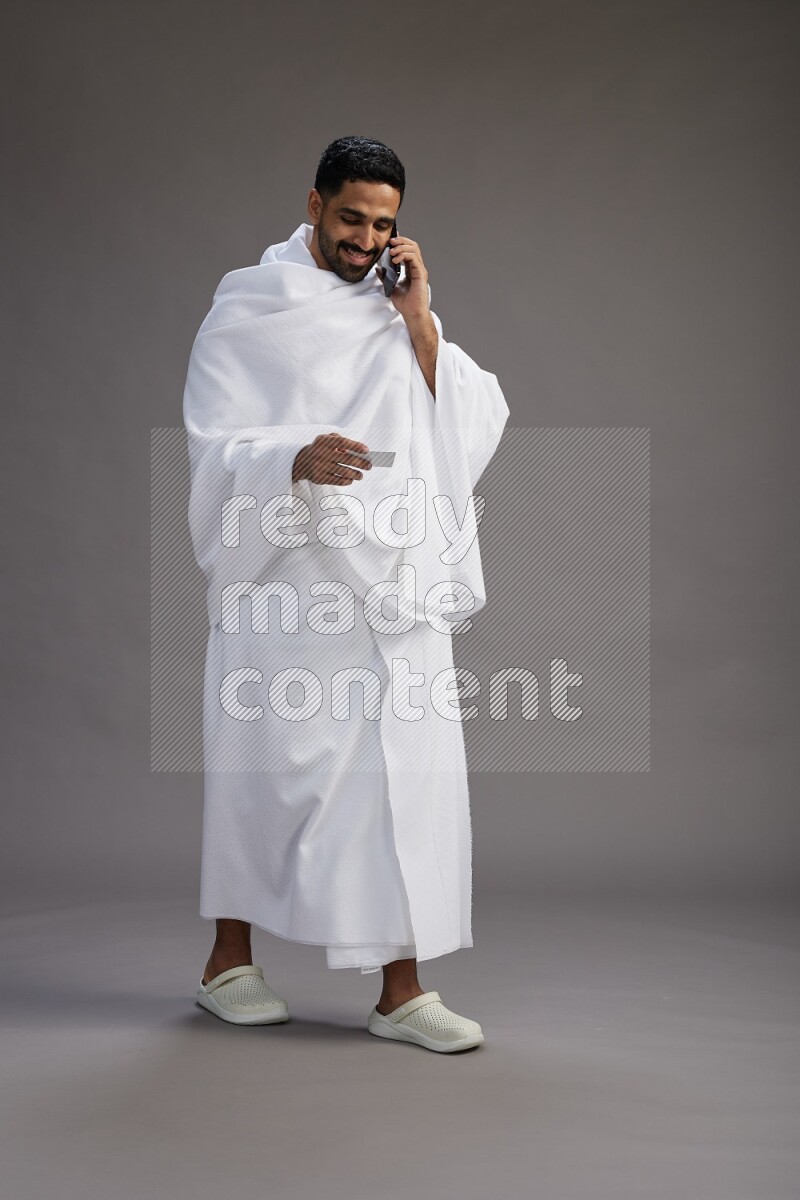 A man wearing Ehram Standing holding ATM card on gray background