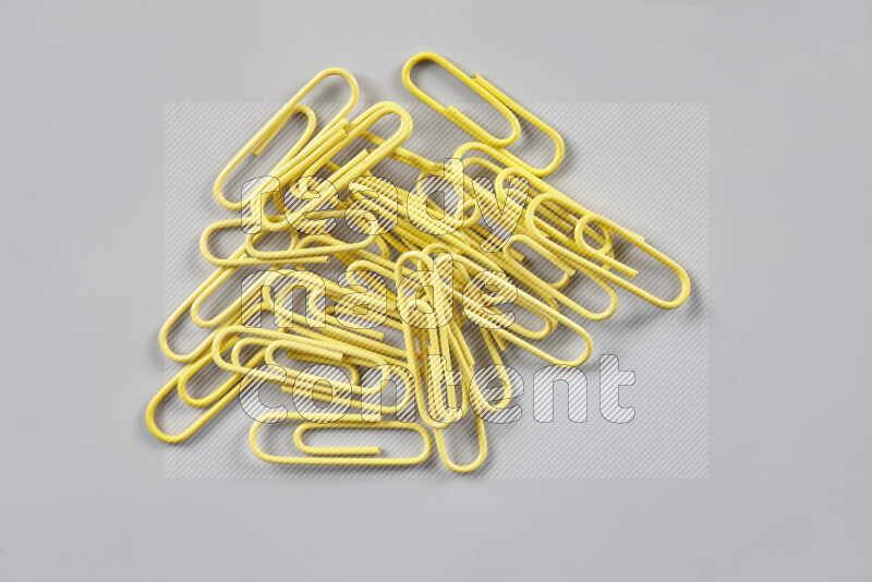 Yellow paper clips isolated on a grey background