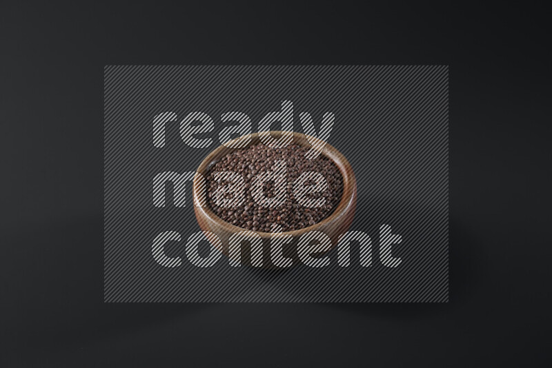 Brown lentils in a wooden bowl on grey background