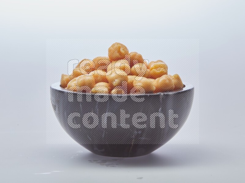 Close up of a boiled chickpeas in a container on white background
