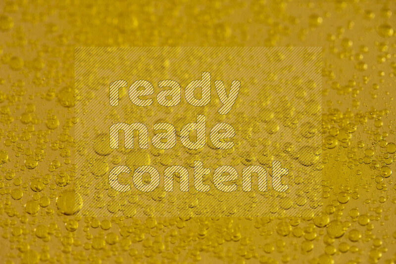 لقطات مقربة لقطرات من الماء على سطح الزيت على خلفية صفراء