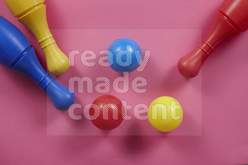 أوتاد البولينج البلاستيكية مع الكرات علي خلفيات ملونة مختلفة (ألعاب أطفال)