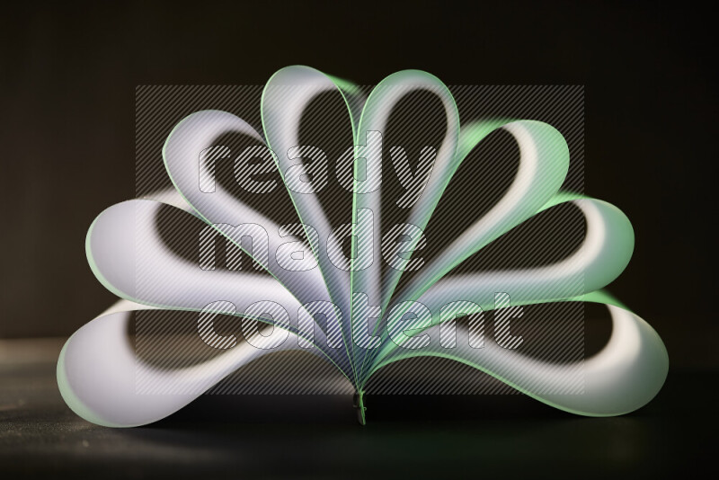 An abstract art piece displaying smooth curves in green and white gradients created by colored light