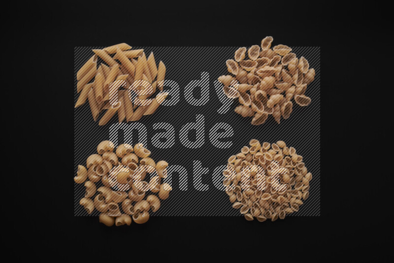 Different pasta types in bunches on black background