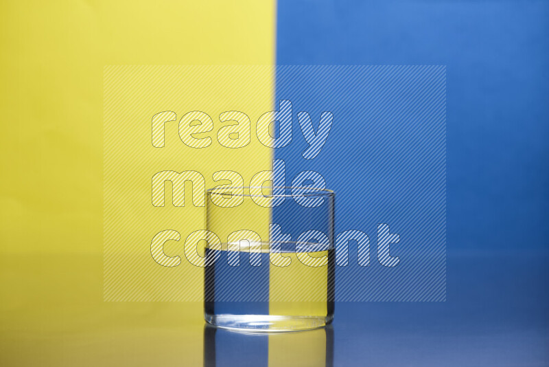 The image features a clear glassware filled with water, set against yellow and blue background