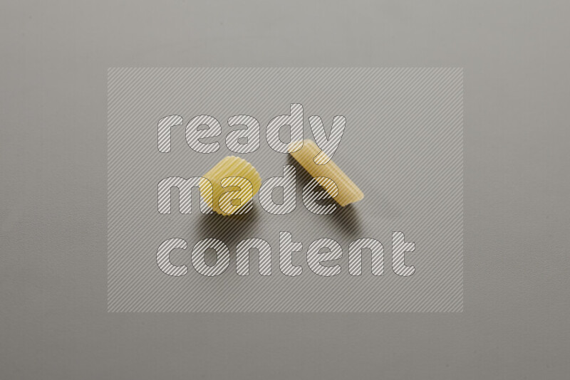 Big rings pasta with other types of pasta on grey background