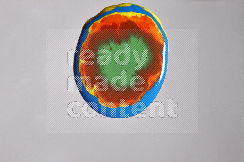 لقطات مقربة لألوان متنوعة تمتزج على خلفية رمادية