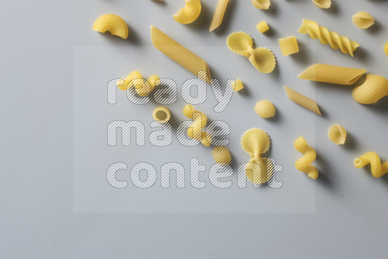 Different pasta types on light blue background