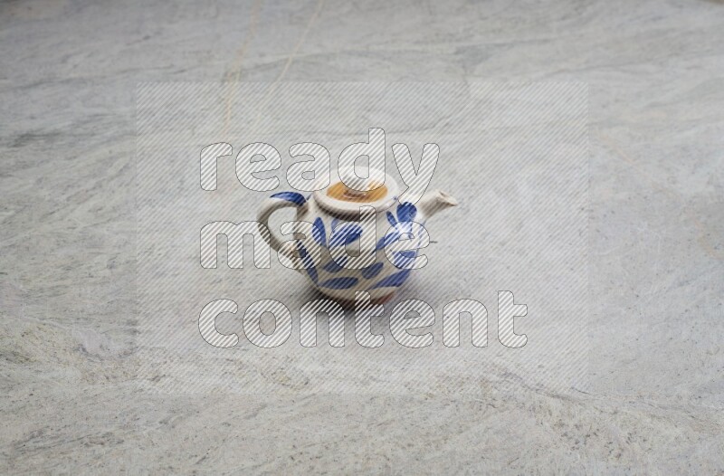 A pottery teapot on grey marble background