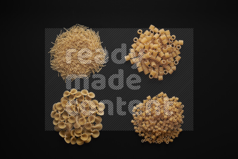 Different pasta types in bunches on black background