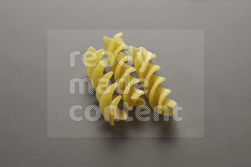 Fusilli pasta on grey background