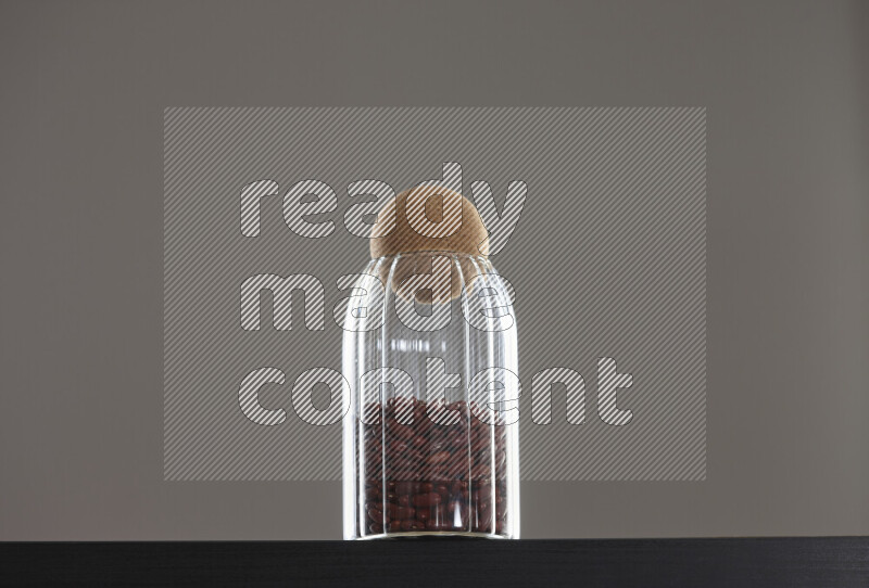 Red kidney beans in a glass jar on black background