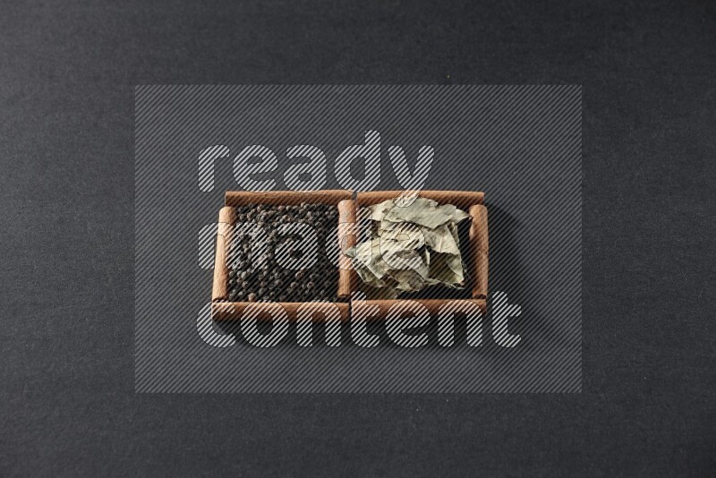 2 squares of cinnamon sticks full of black peppers and bay laurel leaves on black flooring