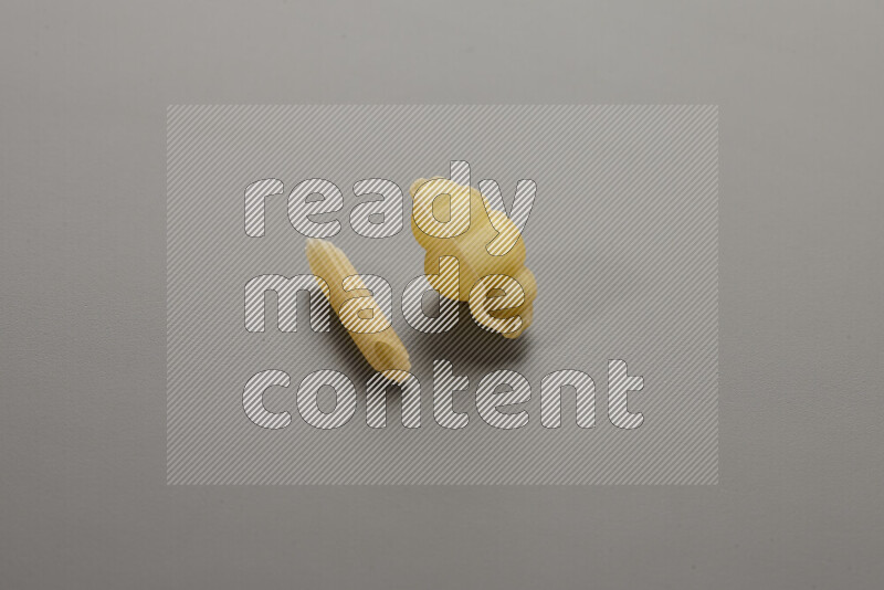 معكرونة فرن صغيرة مع أنواع أخري من المعكرونة علي خلفية رمادية