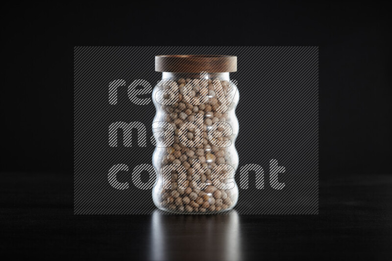 Chickpeas in a glass jar on black background