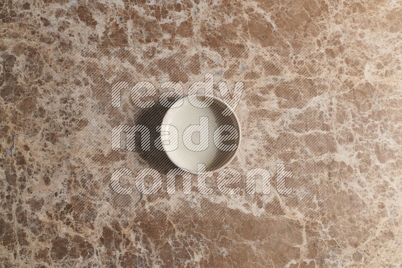 A white pottery bowl on beige marble background