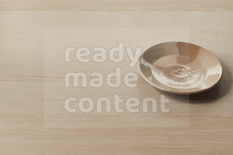 A multicolored pottery plate on light wooden background