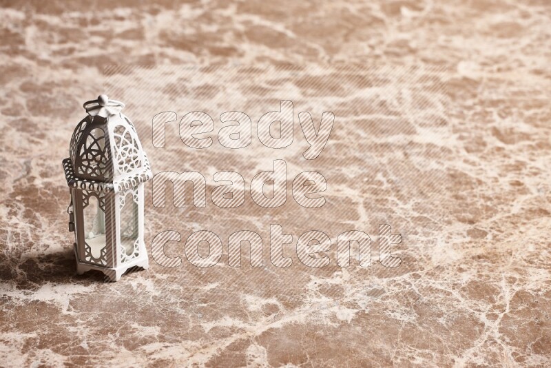 A candle lantern on beige marble background
