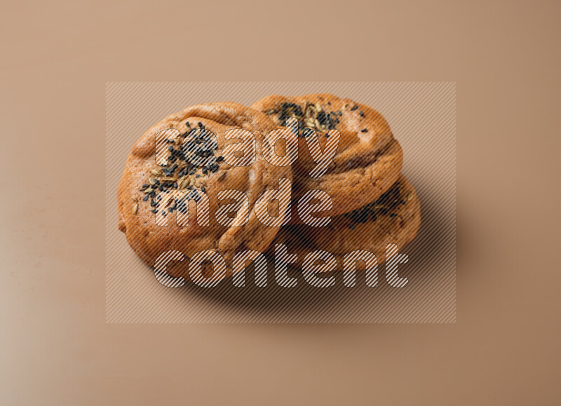 Hasawi cookies field with date and decorated by black seed and Anise grain on a brown background