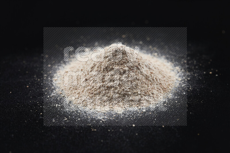 A bunch of onion powder on black background
