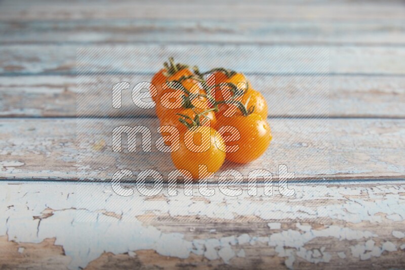 orange cherry tomato vein on a textured blue wooden background 45 degree
