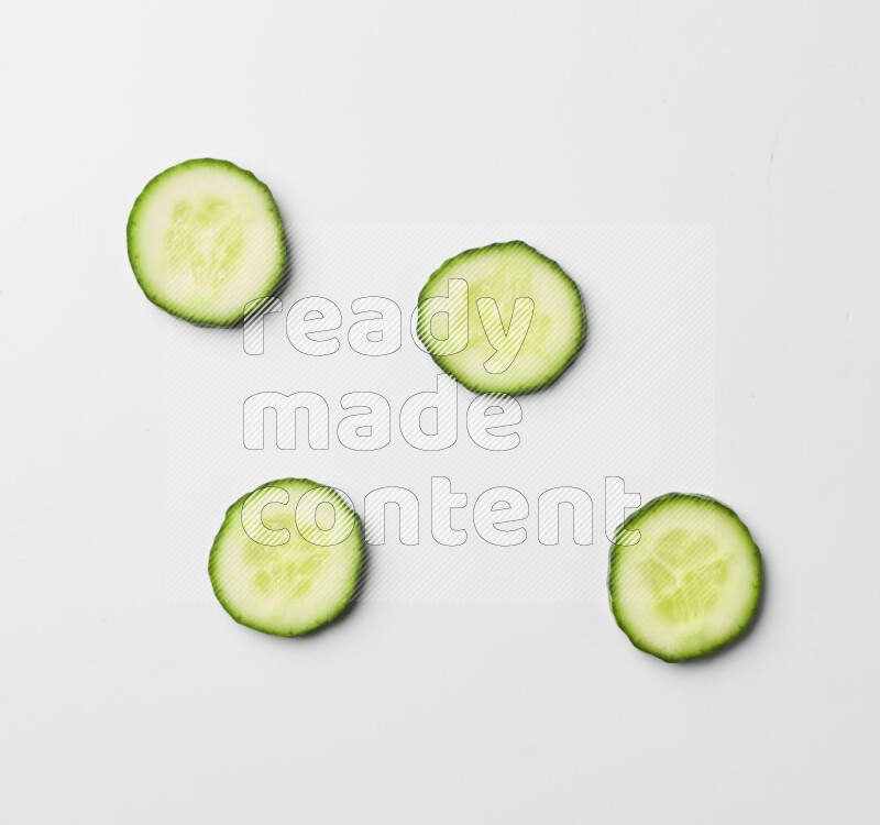Multiple cucumber slices on white background