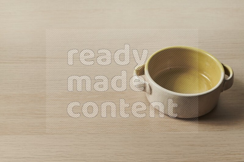A multicolored pottery bowl on light wooden background