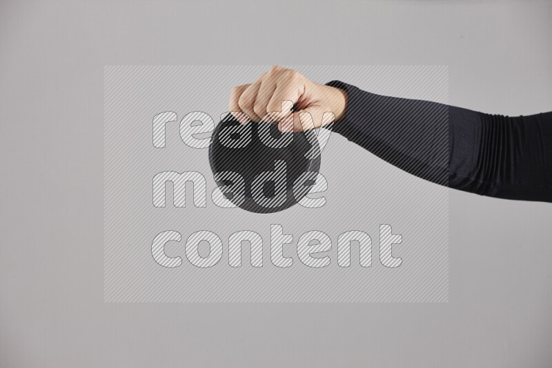 امرأة ترتدي عباءة سوداء تحمل أدوات فخارية مختلفة في أوضاع متعددة