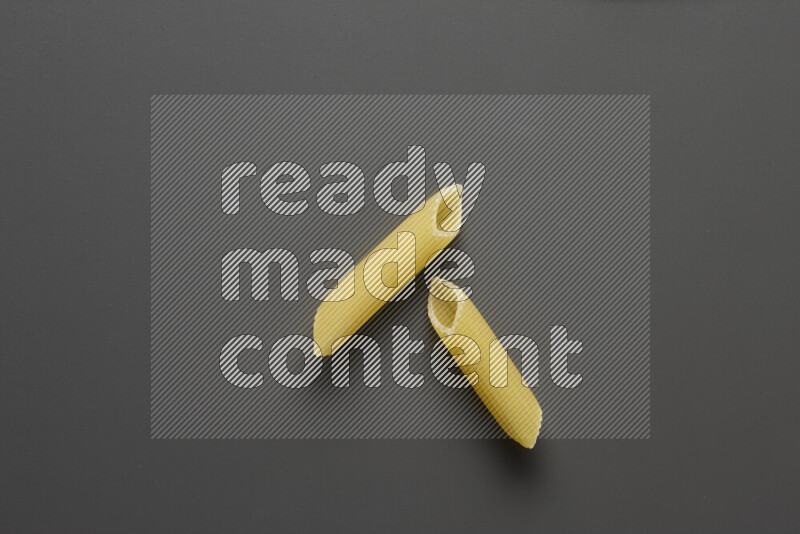 Penne pasta on grey background