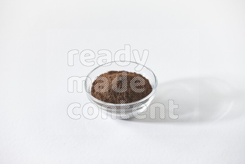 A glass bowl full of cloves powder on white flooring